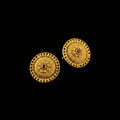 Pair of gold earrings with red gemstones on a black background