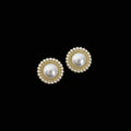 Pair of pearl earrings with gold accents on a dark background