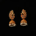 Gold earrings with pearl drops on a black background, branded 'Saheli'.