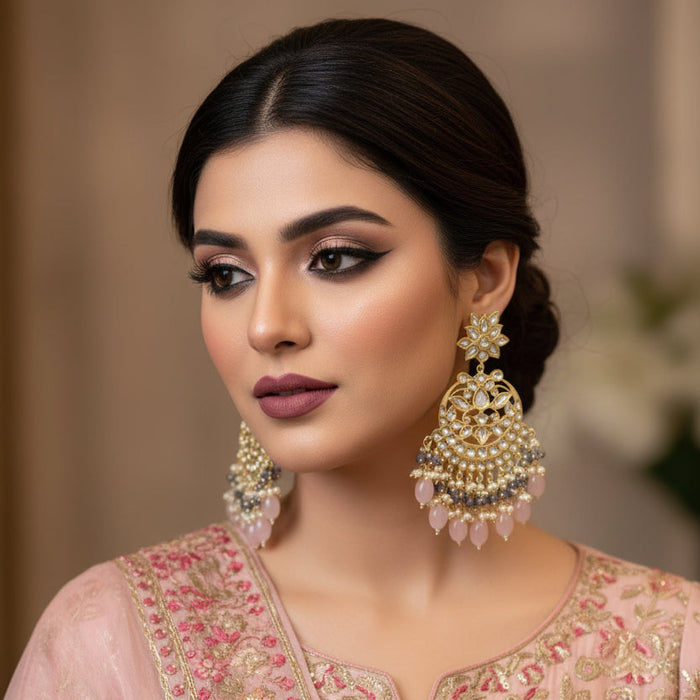 Ornate gold and gemstone earrings on a black background