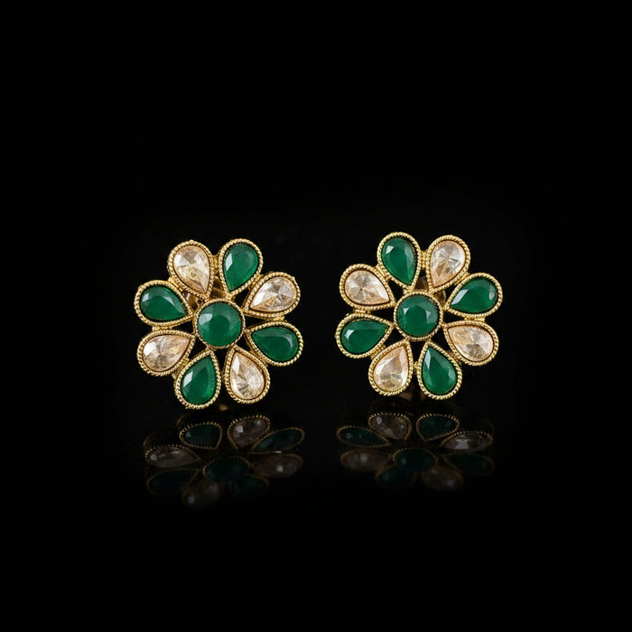 Pair of floral earrings with green and gold design on a gray background, featuring the brand 'Saheli'.