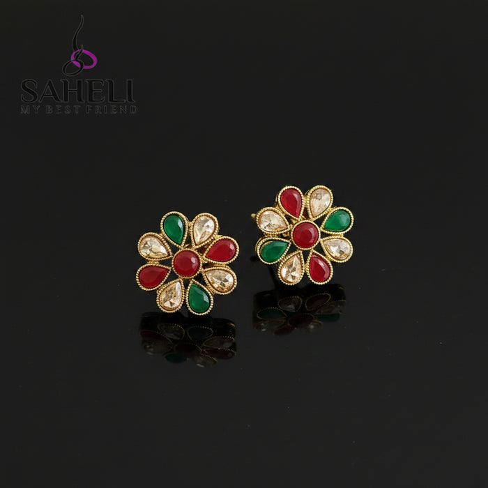 Colorful floral earrings with gemstones on a gray background, branded 'SAHELI'.