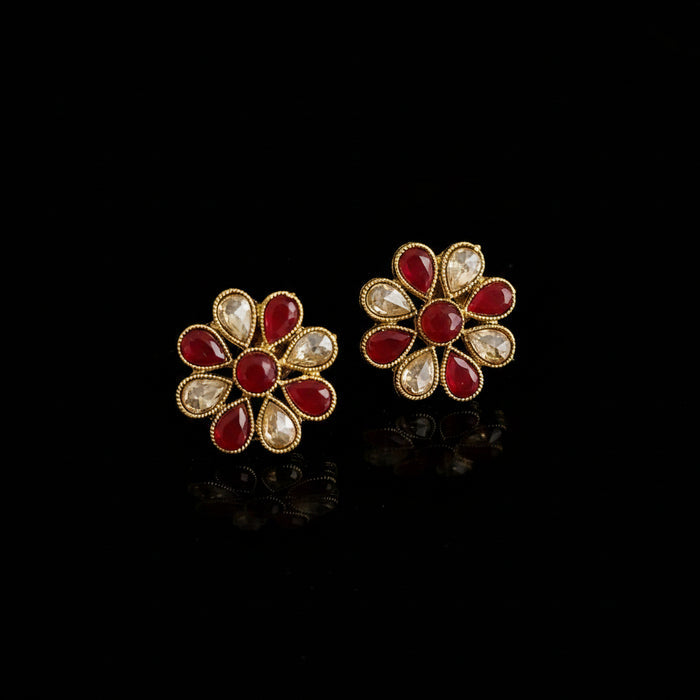Gold and red floral earrings on a gray background with 'SAHELI' branding.