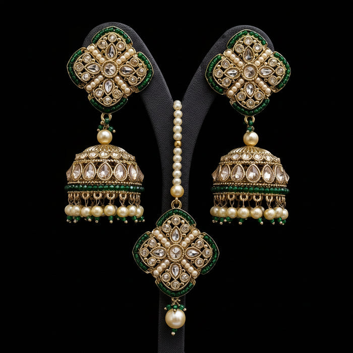 Ornate gold and green earrings with pearls on a gray background, featuring the brand 'SAHELI'.