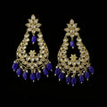 A pair of gold-plated Indian chandelier earrings with clear stone pavé settings and dangling royal blue beads, displayed on a dark reflective surface with the Saheli My Best Friend logo in the top left corner.