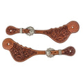 Pair of chestnut leather spur straps tooled edge to edge with flowers and leaves, a round engraved concho over each buckle and a stitched dot border