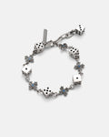 The Gambler’s Faith Bracelet by Statement Collective showcases silver six-sided dice and star-shaped links with blue centers, arranged in an alternating pattern, displayed on a plain light background.