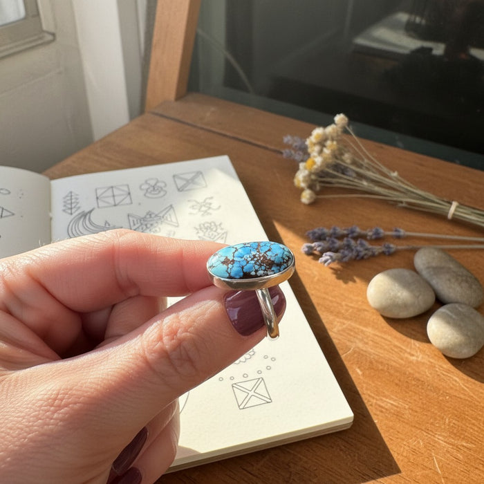 Wildflower Artisans sterling silver ring featuring a 10 carat oval Golden Hills turquoise cabochon with brown matrix.