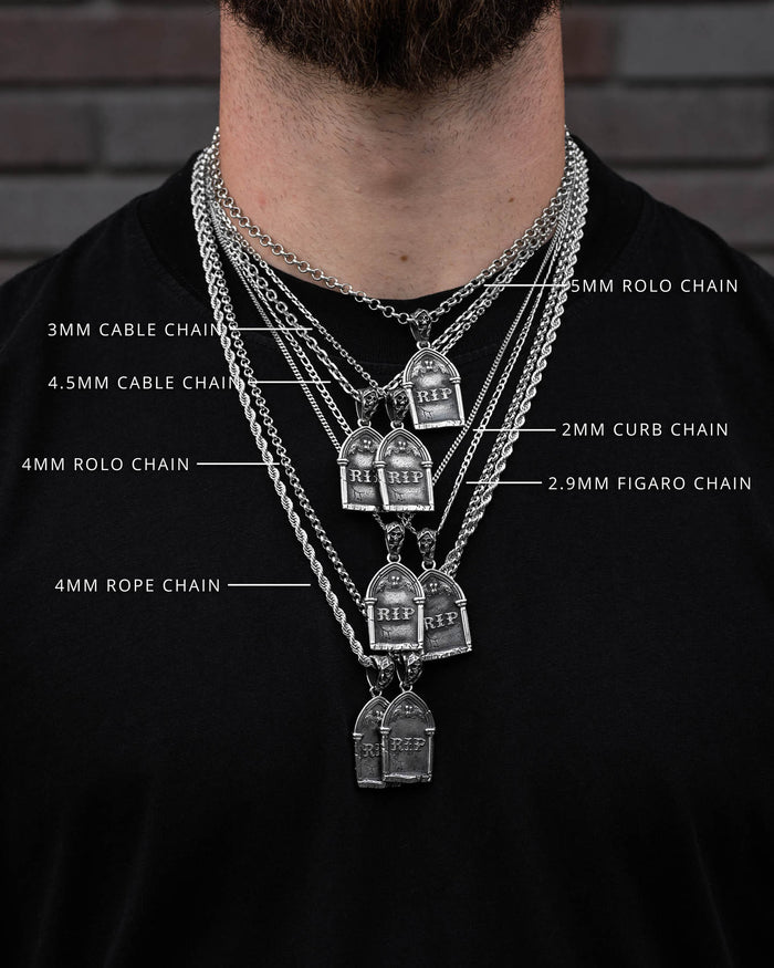A person wears six silver Grim Jewelry chains of different styles—cable, rolo, curb, figaro, and rope—over a black shirt; each features a Gravestone Pendant labeled with its width and type.