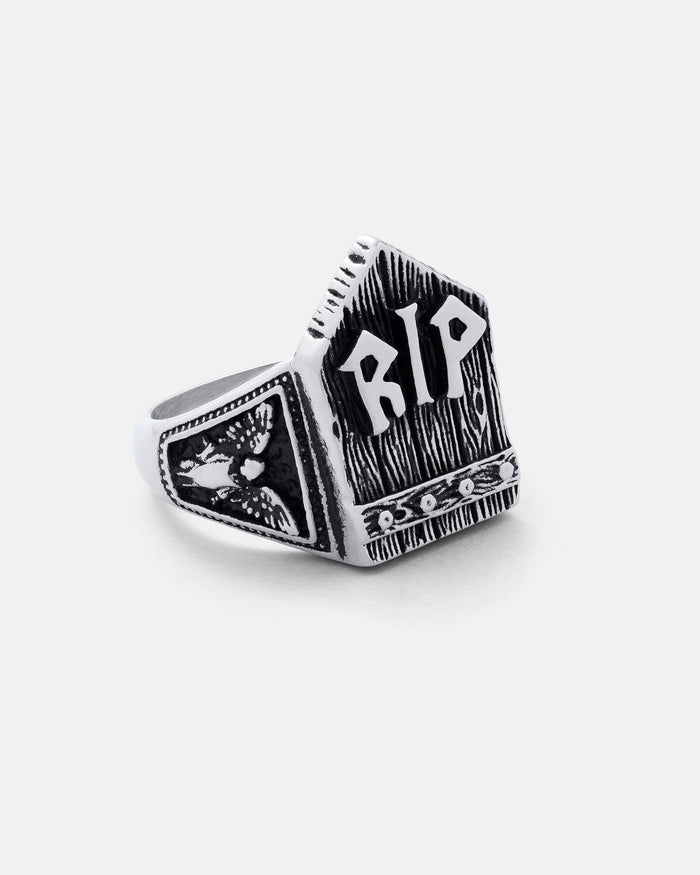 The Gravestone Ring is a silver, tombstone-shaped piece with "RIP" engraved on the front and an owl design on the side. It features a dark, textured finish for bold contrast.
