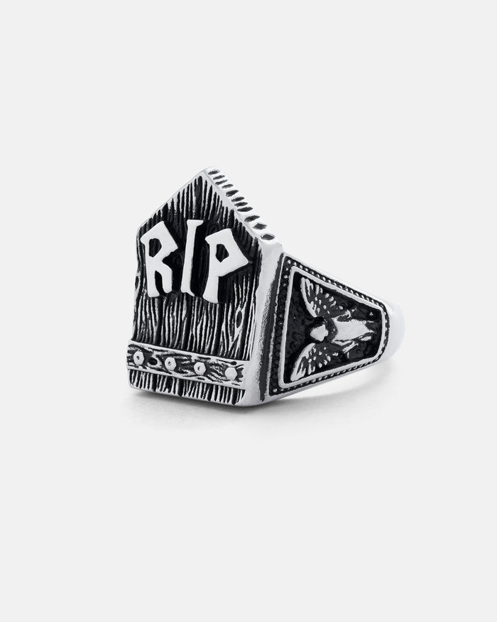 The Gravestone Ring is a silver piece featuring raised RIP letters on a textured background, a detailed bee on one side, and decorative etching along the base for a macabre jewellery statement.