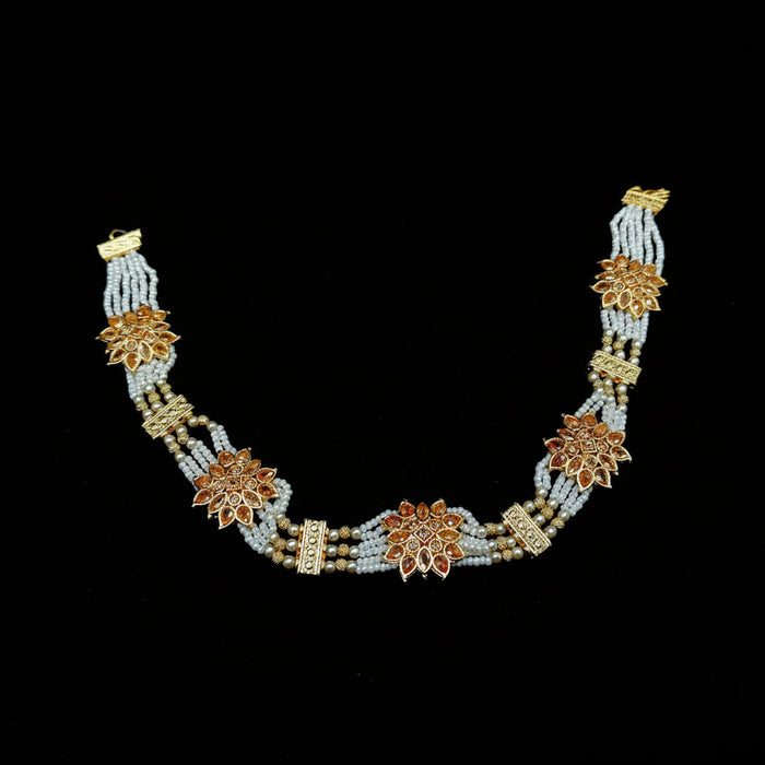 Decorative necklace with floral designs on a black background, featuring the brand 'Saheli'.