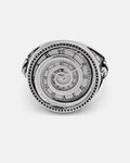 The Infinite Clock Ring by Statement Collective is a silver ring crafted with a detailed spiral clock face, Roman numerals, clock hands, and a mesmerizing spiral pattern at its center.