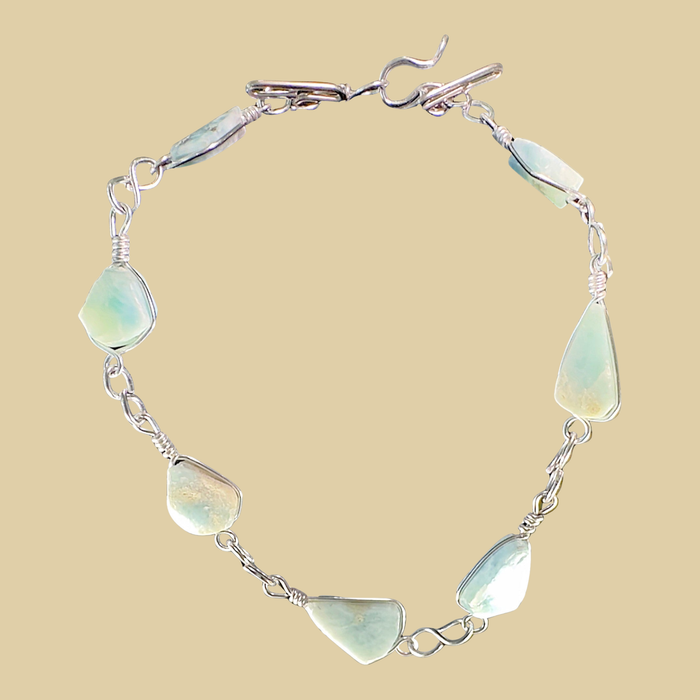 Larimar Adjustable Anklet and Bracelet in Sterling Silver, shown on a desert plaster background