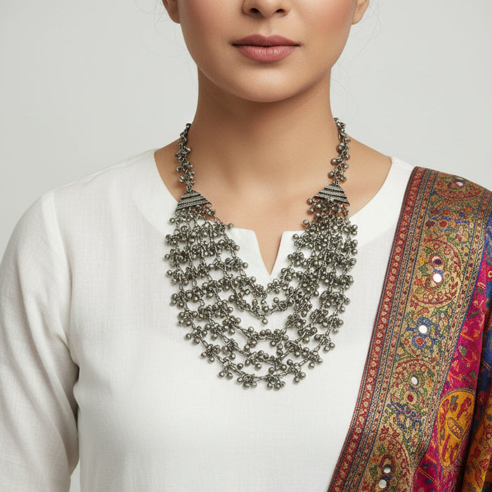 Silver beaded necklace on a dark surface
