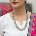 Silver beaded necklace on a dark surface