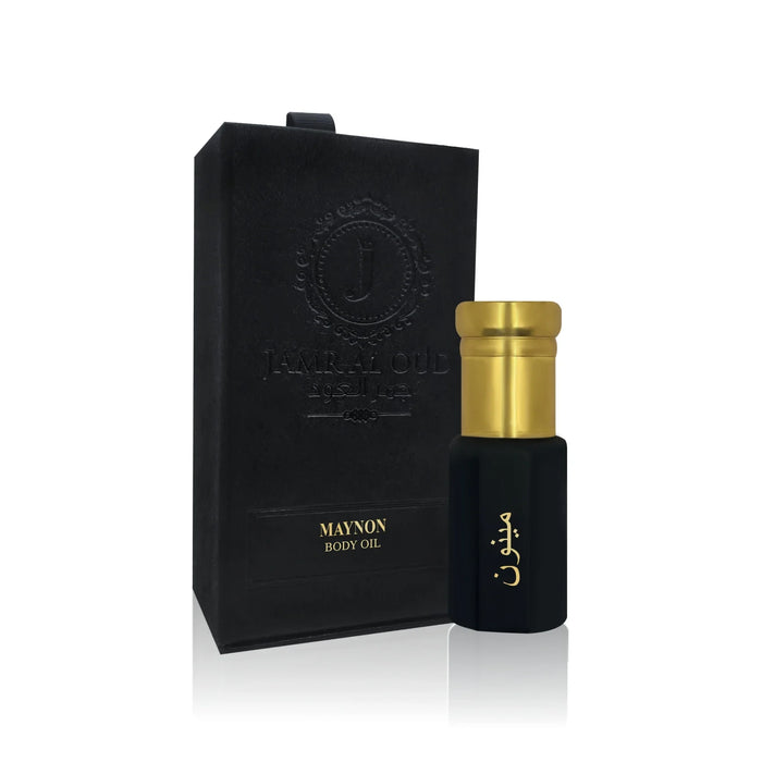 Jamr Al Oud Maynon body oil bottle with gold cap beside elegant black gift box