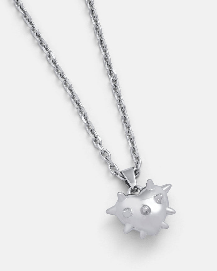 The Mini "Love Hurts" Spiked Heart Pendant is a stainless steel necklace with a metallic heart and rounded spikes, shown on a plain light background—a bold statement piece for any look.