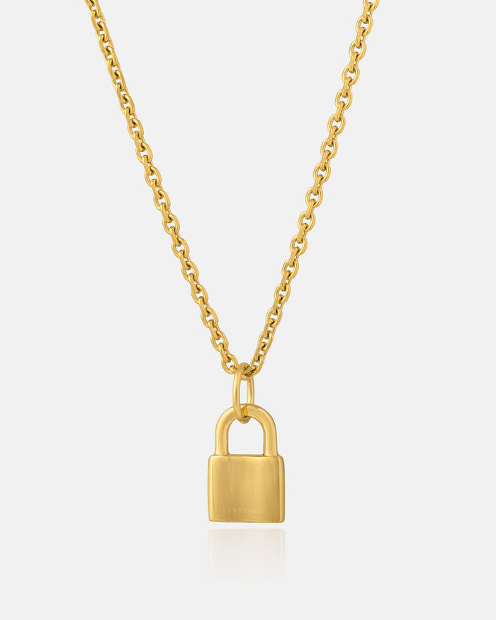 The Mini Padlock Pendant (Gold) is an 18k gold hypoallergenic necklace featuring a small padlock charm at its center, shown against a plain white background to highlight its elegant design.
