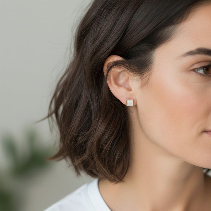 Wildflower Artisans square mother of pearl stud earrings in sterling silver worn on a woman's ear