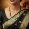 A gold and white crystal jewelry set featuring a necklace and matching earrings, displayed on a black card with the brand name 'SAHELI MY BEST FRIEND' visible on the reflective dark surface.