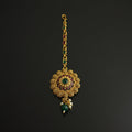 Gold necklace with green gemstones on a black background