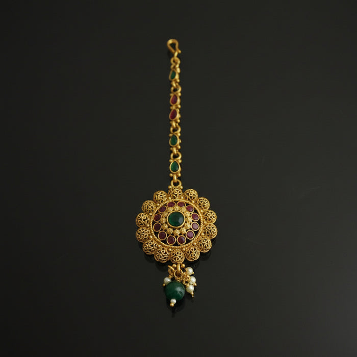 Gold necklace with green gemstones on a black background