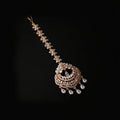 Decorative hair accessory with gold and crystal elements on a dark background