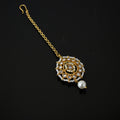 Decorative gold necklace with a pearl on a black background