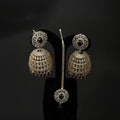 Gold and diamond earrings on a black stand with 'Saheli' branding.