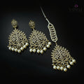 Jewelry set with earrings and a necklace on a dark background, featuring the brand 'Saheili'.