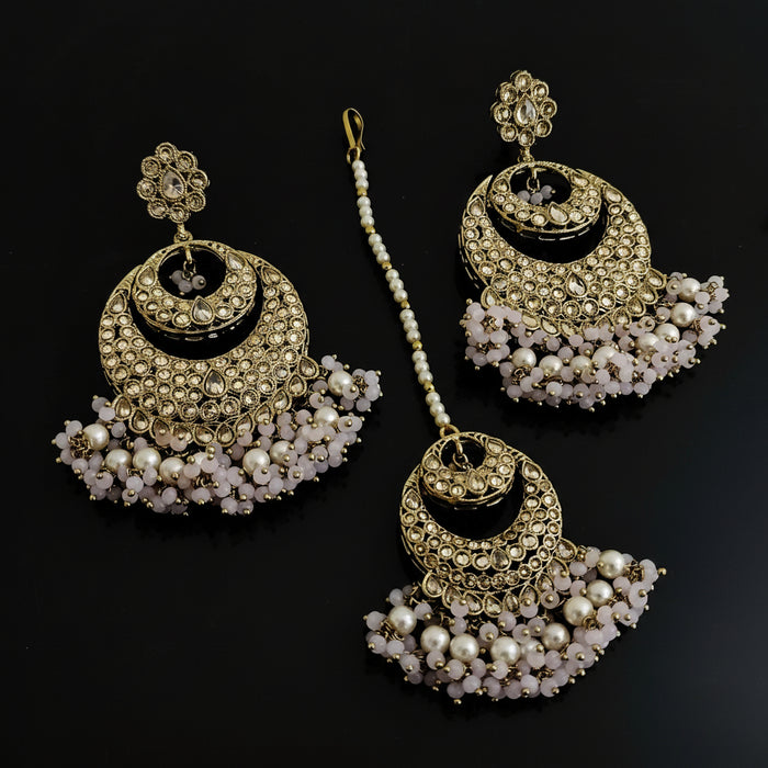 Set of gold and pearl earrings on a dark background