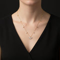 Gold necklace with a fan-shaped pendant on a dark background