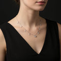 Delicate necklace with butterfly pendant and teardrop-shaped crystals on a black background