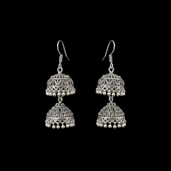 Silver earrings on a gray stand with 'Sahell' branding.