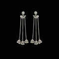 Silver earrings with chain and bead details on a gray background, branded 'SAHELI'.