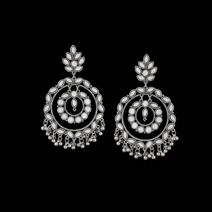 Pair of silver earrings with intricate designs on a black background