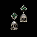 Pair of silver and green earrings on a black stand with a gray background