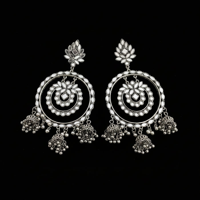 Pair of silver earrings with intricate designs on a dark background