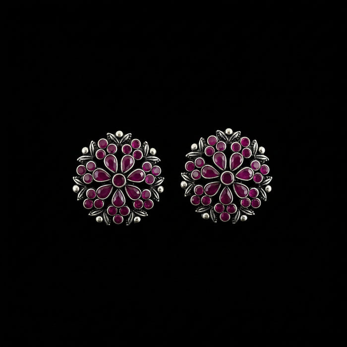 A pair of silver-toned Indian Kundan earrings decorated with pink and red stones, displayed on a dark gray reflective surface with the brand name 'SAHELI MY BEST FRIEND' printed at the top.
