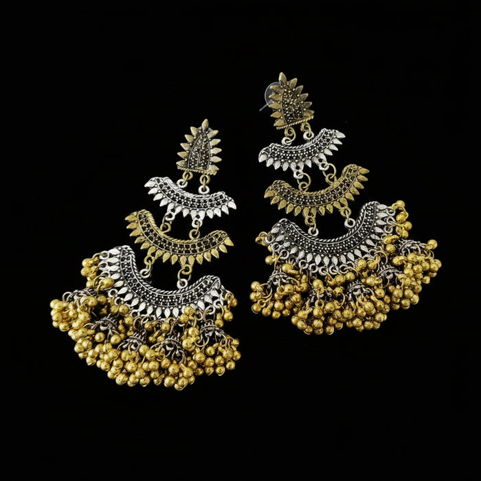 Pair of gold and silver earrings with 'SAHELI' branding on a dark background