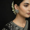 Pair of silver floral patterned earrings on a dark background