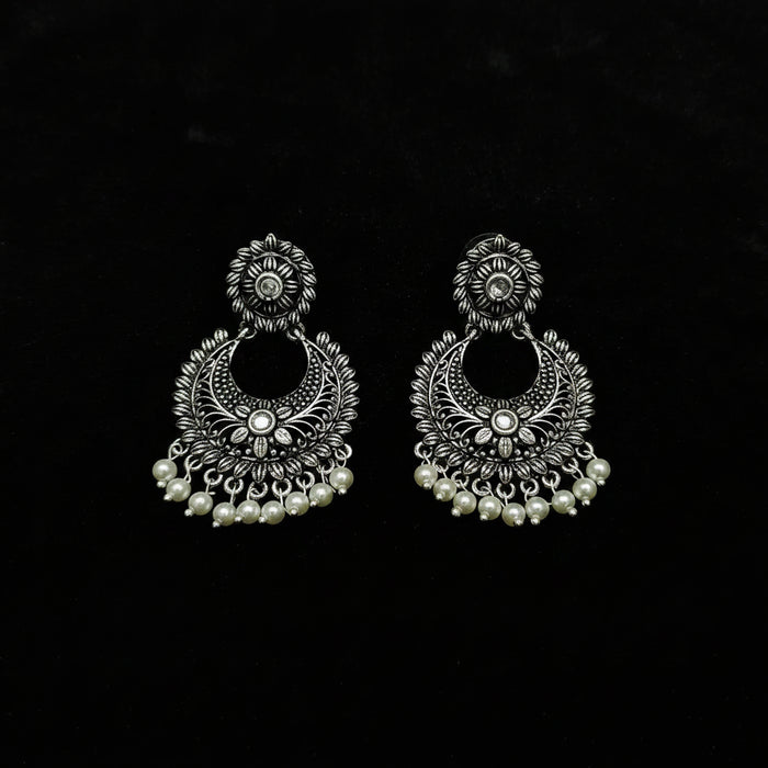 Pair of silver earrings with pearl accents on a black background