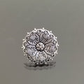 Silver ring with intricate design on a gray background