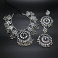 Silver necklace and earrings on a dark background