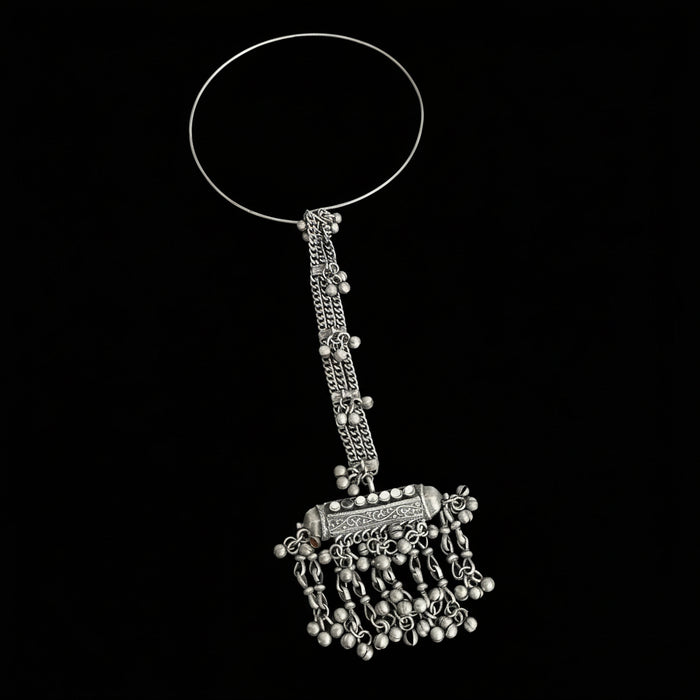 Silver bangle with decorative elements on a gray background, featuring the brand 'Saheli'.