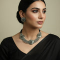Silver necklace and earrings set on a dark background