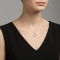 Gold necklace with a heart-shaped pendant on a branded card