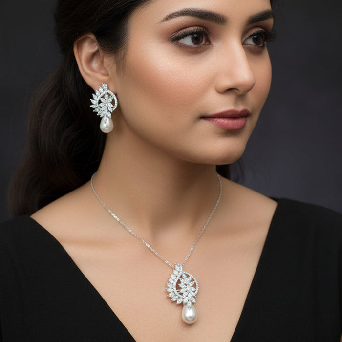 Jewelry set with silver earrings and a necklace on a dark background