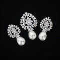 Pair of silver earrings with pearl drops on a black background